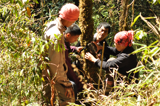 Alemba along with other forest guards fixes a camera trap.