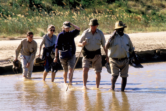 Ian Player, along with Magqubu Ntombela, leads a Wilderness Leadership School trail across the river iMfolozi, within the iMfolozi wilderness, KwaZulu-Natal, Republic of South Africa in 1985.