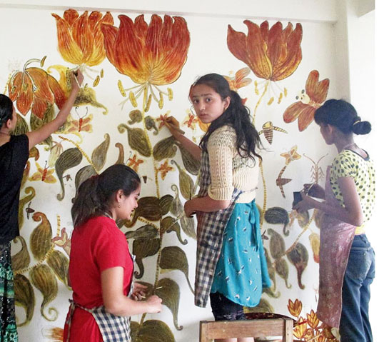 Children from the Himalayan Institute of Natural History Art, which the artist helped establish, work on a mural using natural colours.