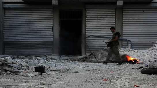 Syrian Army soldier walking among rubble in Aleppo, Syria