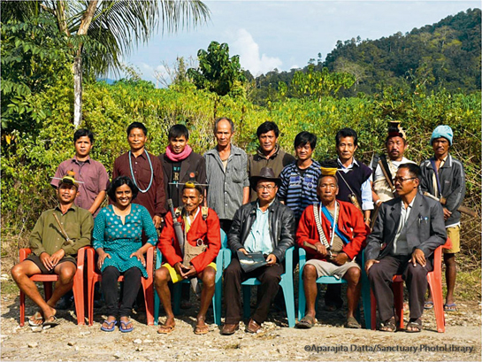 A photograph from 2012 of the Hornbill Nest Protectors' Team, standing (left to right): 1. Bidda, 2. Pahi Tachang, 3. Bruno Nabum (former coordinator), 4. Tade Tok, 5. Suraj Bagang, 6. Rungfe Paffa, 7. Gingma Tachang and 8. Nyima Nampe (village headman). Sitting (left to right): Budhiram Tai, Amruta Rane (Nature Conservation Foundation biologist), Tajeng Tachang, Tana Tapi (Field Director of Pakke Tiger Reserve), Tajik Wage and Takam Nabum.