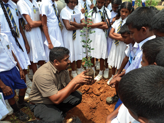 Sudath Abeysinghe, BECT Project Coordinator, demonstrates how to plant a tree.