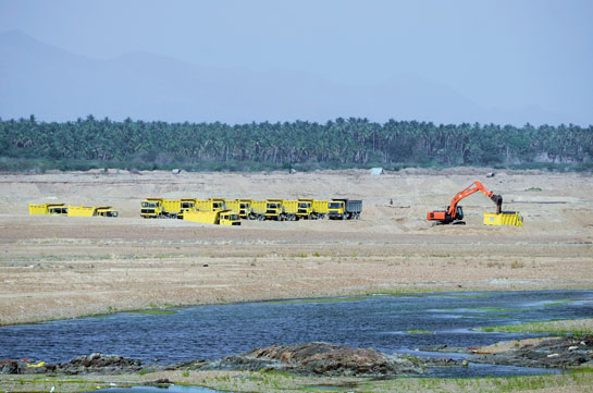 Trucks line up to transport sand from the banks of the Cauvery river.