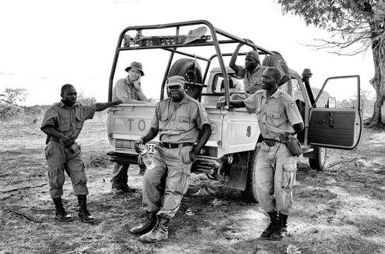 This photograph shows Law Enforcement Manager Jose Sitoe (center, holding a bottle of water) and other reserve scouts taking a rest while on patrol in Mozambique's Niassa Reserve. The country's diverse wildlife has been hard hit by poaching in recent years. This photograph shows Law Enforcement Manager Jose Sitoe (center, holding a bottle of water) and other reserve scouts taking a rest while on patrol in Mozambique's Niassa Reserve. The country's diverse wildlife has been hard hit by poaching in recent years.