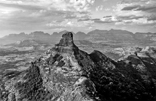 Kalsubai, at 1,646 m., is the highest mountain in the Sahyadri, south of the industrial city of Nashik. The prominent pinnacle in the foreground is the Ratangad Khunta, a volcanic plug that is a significant landmark. The area around Ratangad and Kalsubai makes up the northernmost part of the Sahyadri (Western Ghats).