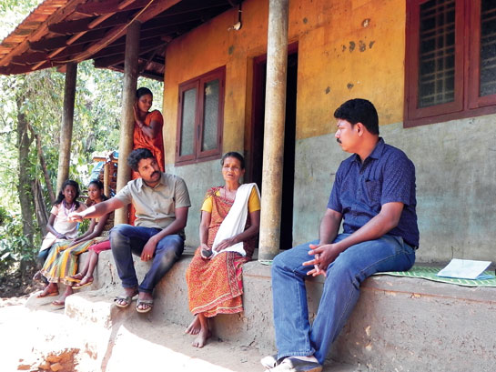 WTI's Shajan M. and K. Ramkumar with 55-year-old Devi (centre) at her house in Anappara.